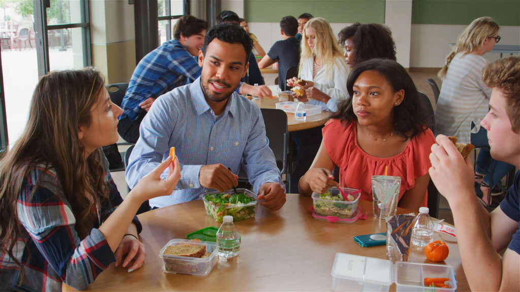 Staff And Students In Cafeteria Of High School College Or University Eating Lunch Together - Christian Counselors of Mooresville