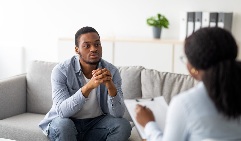 Psychological help service. Depressed male patient having psychotherapy session with counselor at mental health clinic - Christian Counselors of Mooresville Take advantage of your college's counseling services.